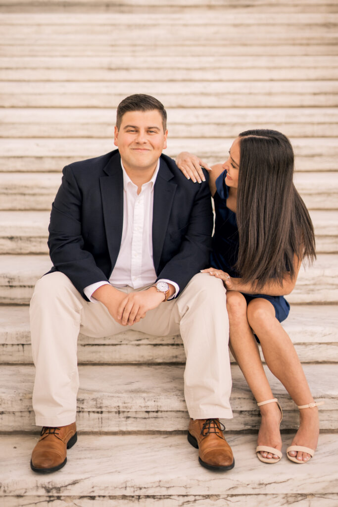 engaged couple sitting on steps at Detroit institute of arts